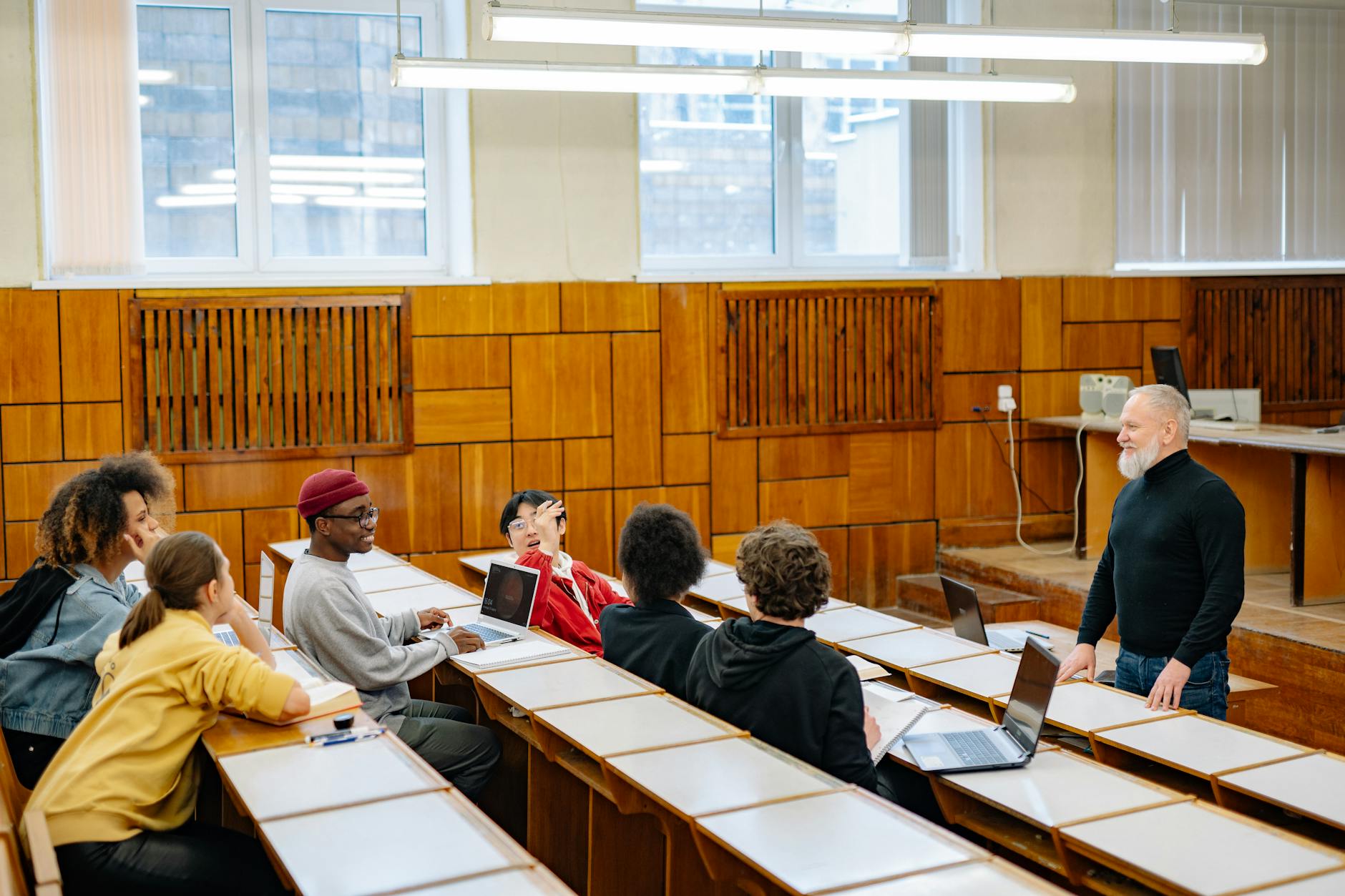 University students in a diverse classroom engaging in a discussion with their professor